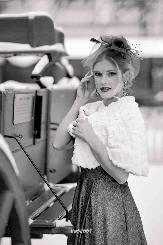 Winter wedding bride standing beside a vintage carriage in Calgary